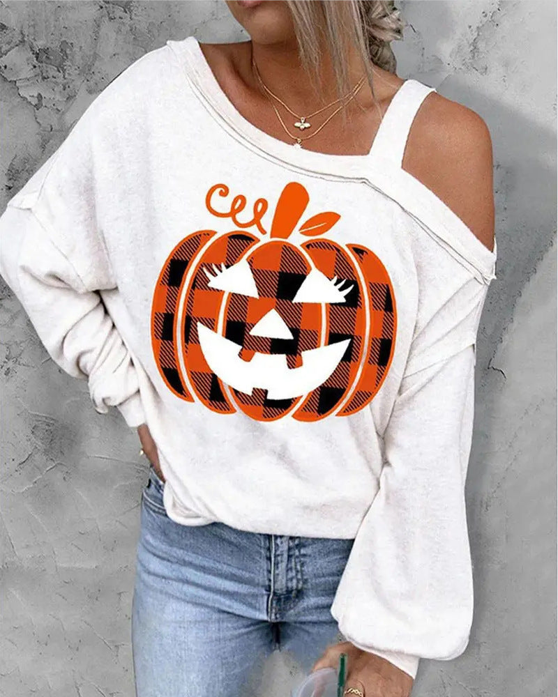 White off-shoulder sweatshirt with a plaid pumpkin design on a gray background