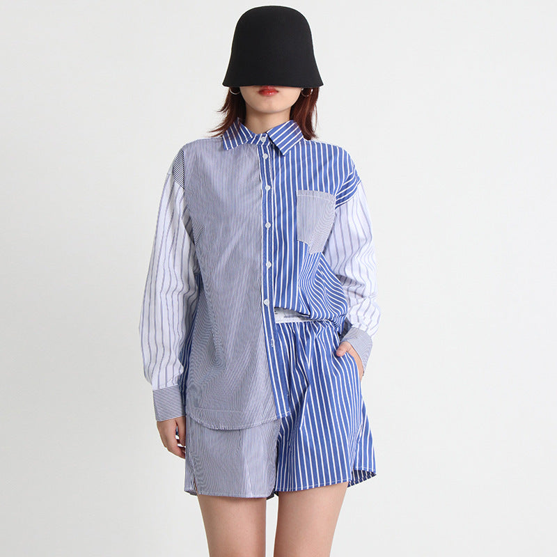 A woman wearing a long-sleeve shirt and shorts set with a striped pattern, paired with a black hat and sunglasses.