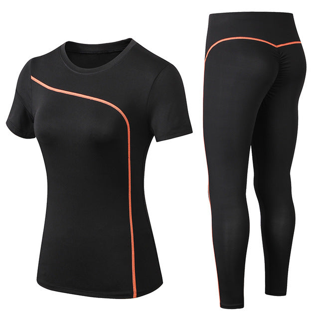 Black athletic shirt and leggings with orange accents on a white background