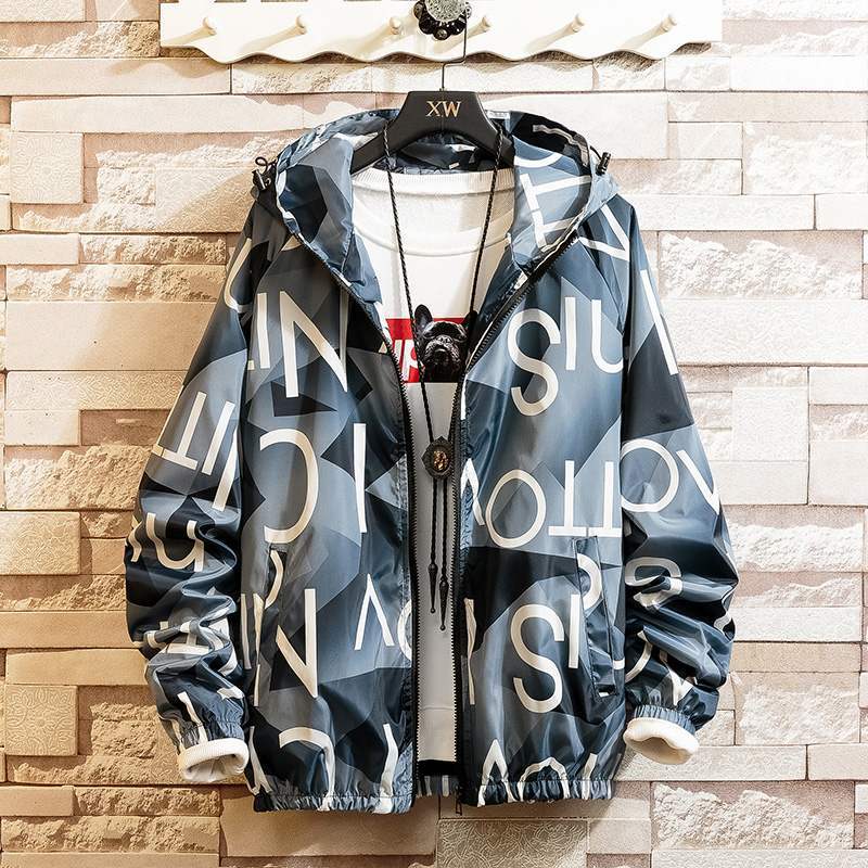 Hoodie coat with a graphic print design in black, white, and yellow colors, displayed on a mannequin against a brick wall background.