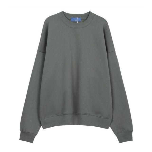 A person wearing a dark grey Urban Fade Washed Pullover Hoodie with a high hood and oversized fit, paired with black pants. The hoodie has a washed character print on the front.