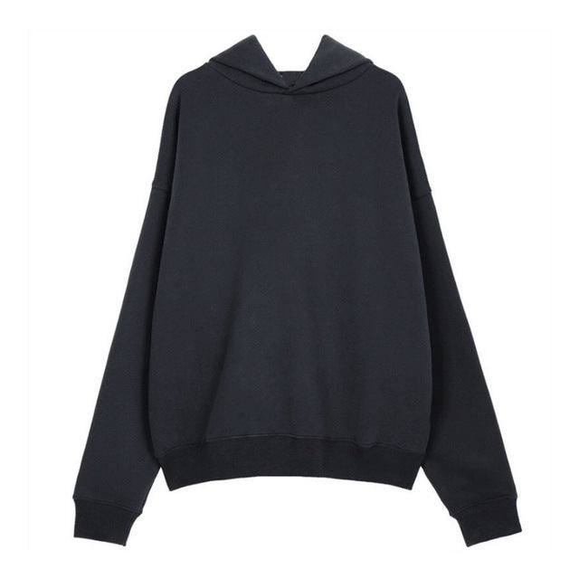 A person wearing a dark grey Urban Fade Washed Pullover Hoodie with a high hood and oversized fit, paired with black pants. The hoodie has a washed character print on the front.