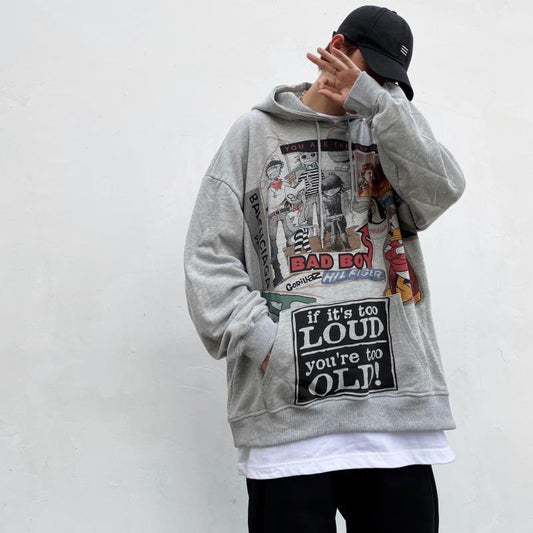 A person wearing a gray Urban Rebel graphic sweatshirt with a hood, featuring a bold, cartoon-inspired design.