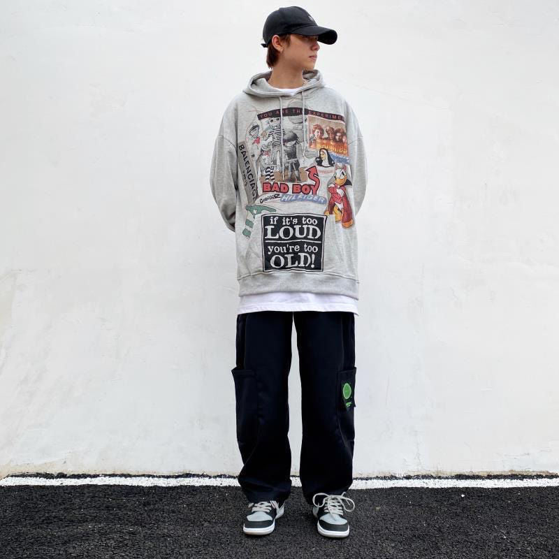 A person wearing a gray Urban Rebel graphic sweatshirt with a hood, featuring a bold, cartoon-inspired design.