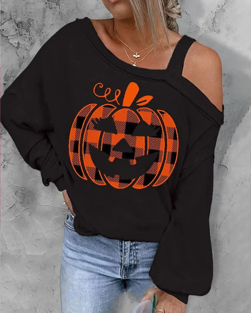 Black sweatshirt with orange plaid pumpkin design worn by a person on a gray background