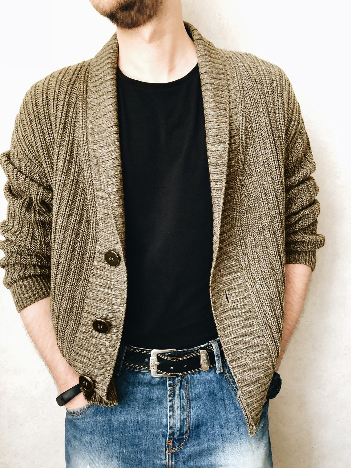 A person wearing a brown Urban Knit V-Neck Cardigan over a black t-shirt and blue jeans.