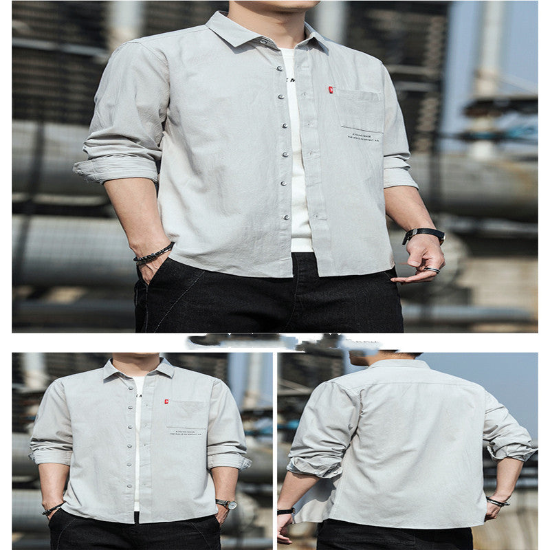A male fashion model wearing a white Urban Wave men's fashion top with a lapel collar, long sleeves, and a slim fit. The top is displayed in an urban setting with a tiled wall in the background.