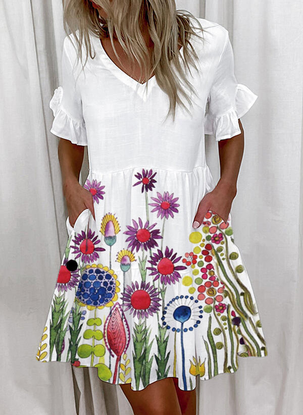 A woman wearing a white knee-length dress with blue floral print, V-neckline, and lotus leaf short sleeves.