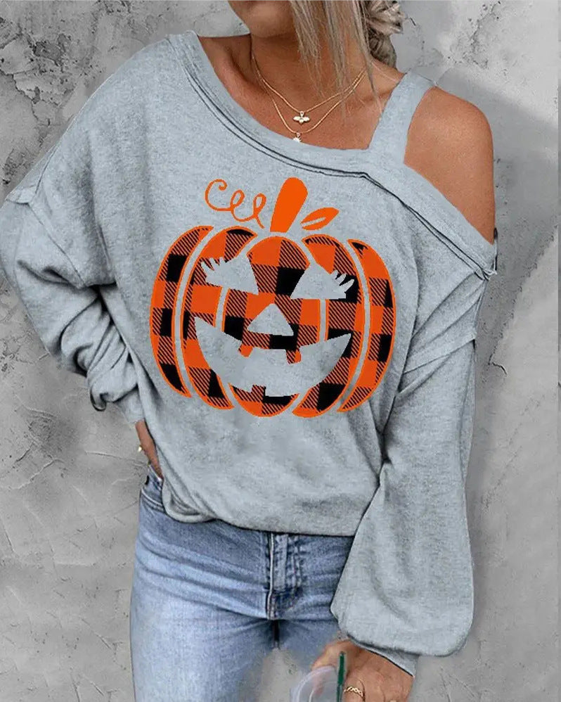 Person wearing a gray sweatshirt with a plaid pumpkin design on a light gray background