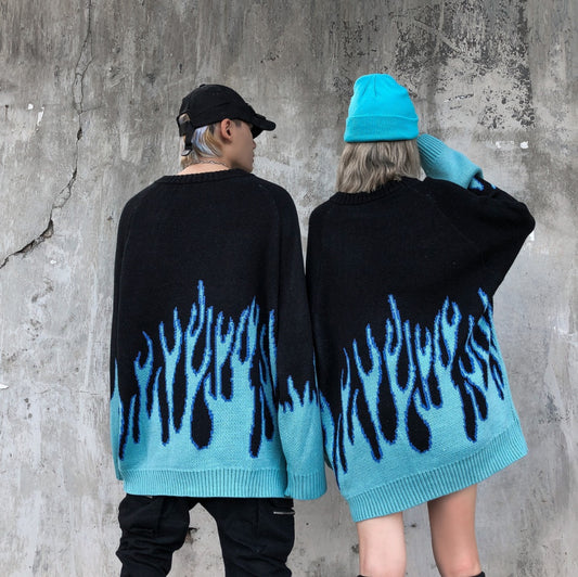 Two individuals wearing black sweatshirts with a blue flame pattern, viewed from the back