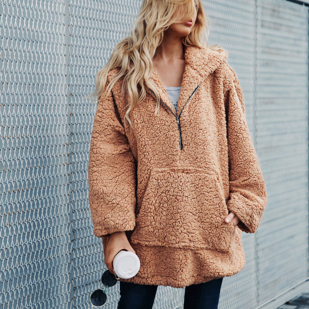 A woman wearing a brown plush plus sweater coat with a hood, oversized design, and front pockets.