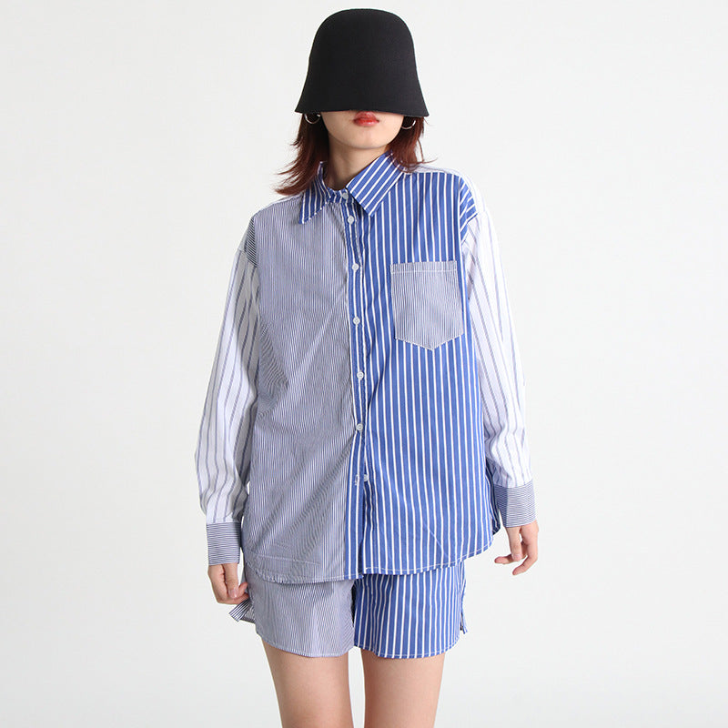 A woman wearing a long-sleeve shirt and shorts set with a striped pattern, paired with a black hat and sunglasses.