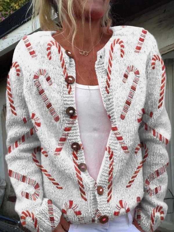 Person wearing a white cardigan with candy cane patterns outdoors.