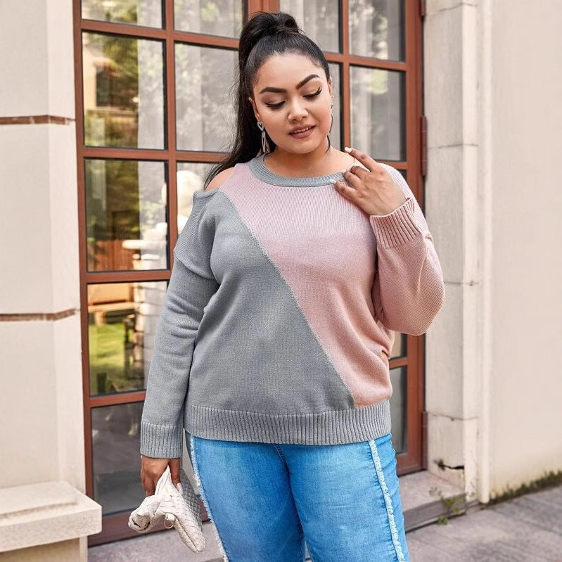 A woman wearing a color-blocked knit sweater with a hood, in pink and gray shades, paired with blue jeans.