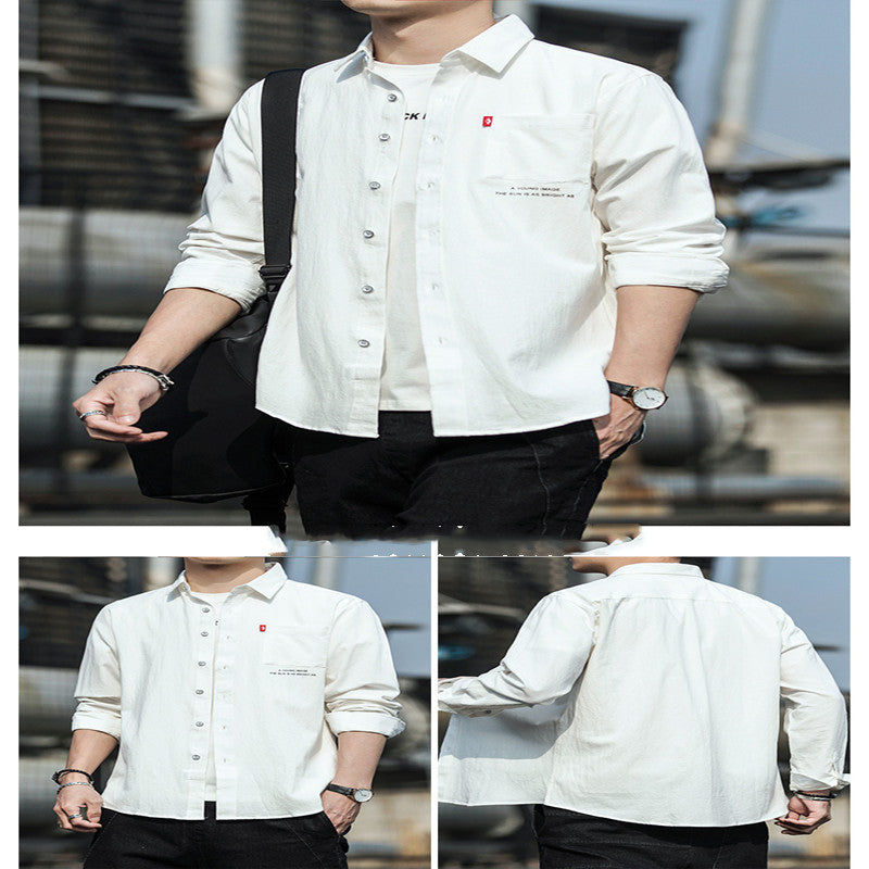 A male fashion model wearing a white Urban Wave men's fashion top with a lapel collar, long sleeves, and a slim fit. The top is displayed in an urban setting with a tiled wall in the background.