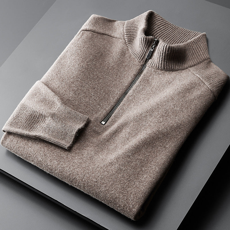 A brown oversized cardigan with a zipper at the neck, laid flat on a grey surface.