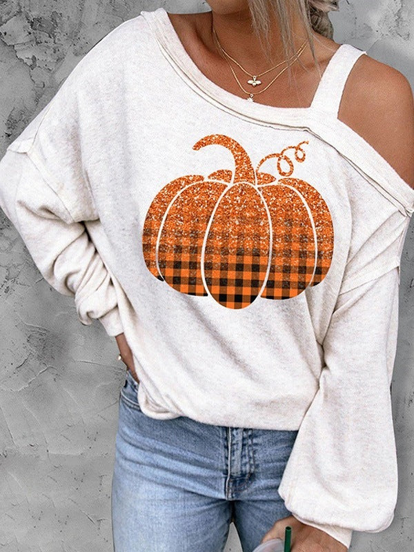 Person wearing a white sweatshirt with a plaid pumpkin design on a gray background