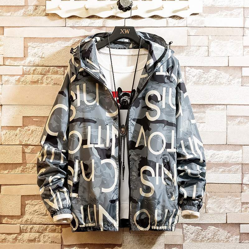 Hoodie coat with a graphic print design in black, white, and yellow colors, displayed on a mannequin against a brick wall background.