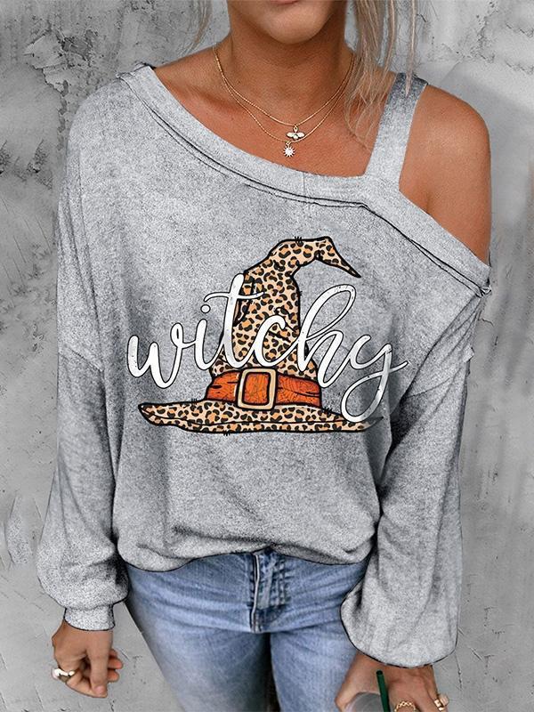 Person wearing a gray sweatshirt with 'witchy' and leopard print design, standing against a neutral background.