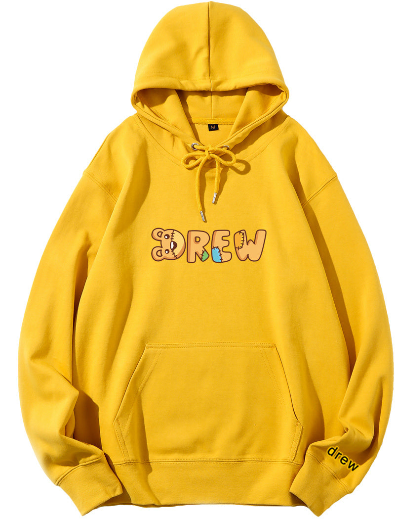 Yellow hoodie with pink text graphic on the front and a small logo on the lower right sleeve.