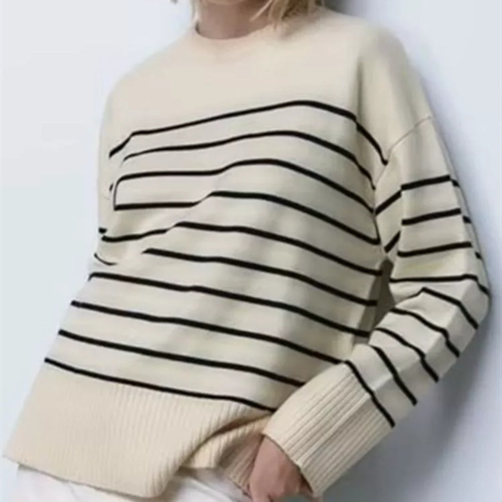 A woman wearing a beige and black striped knit pullover.