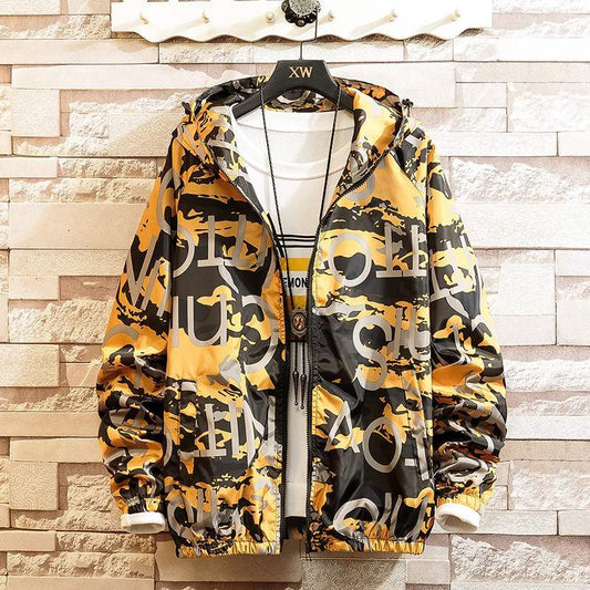 Hoodie coat with a graphic print design in black, white, and yellow colors, displayed on a mannequin against a brick wall background.