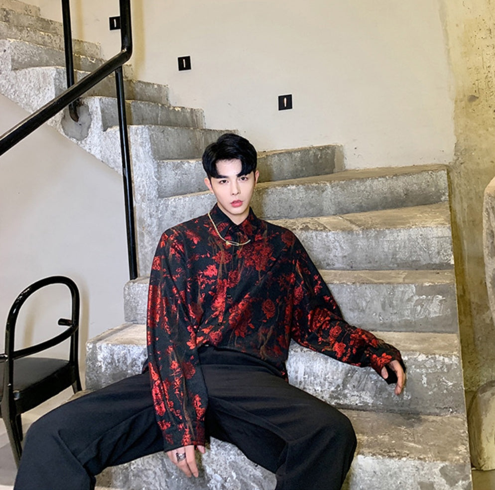 A person wearing a floral print hip hop top with a round neckline and long sleeves.