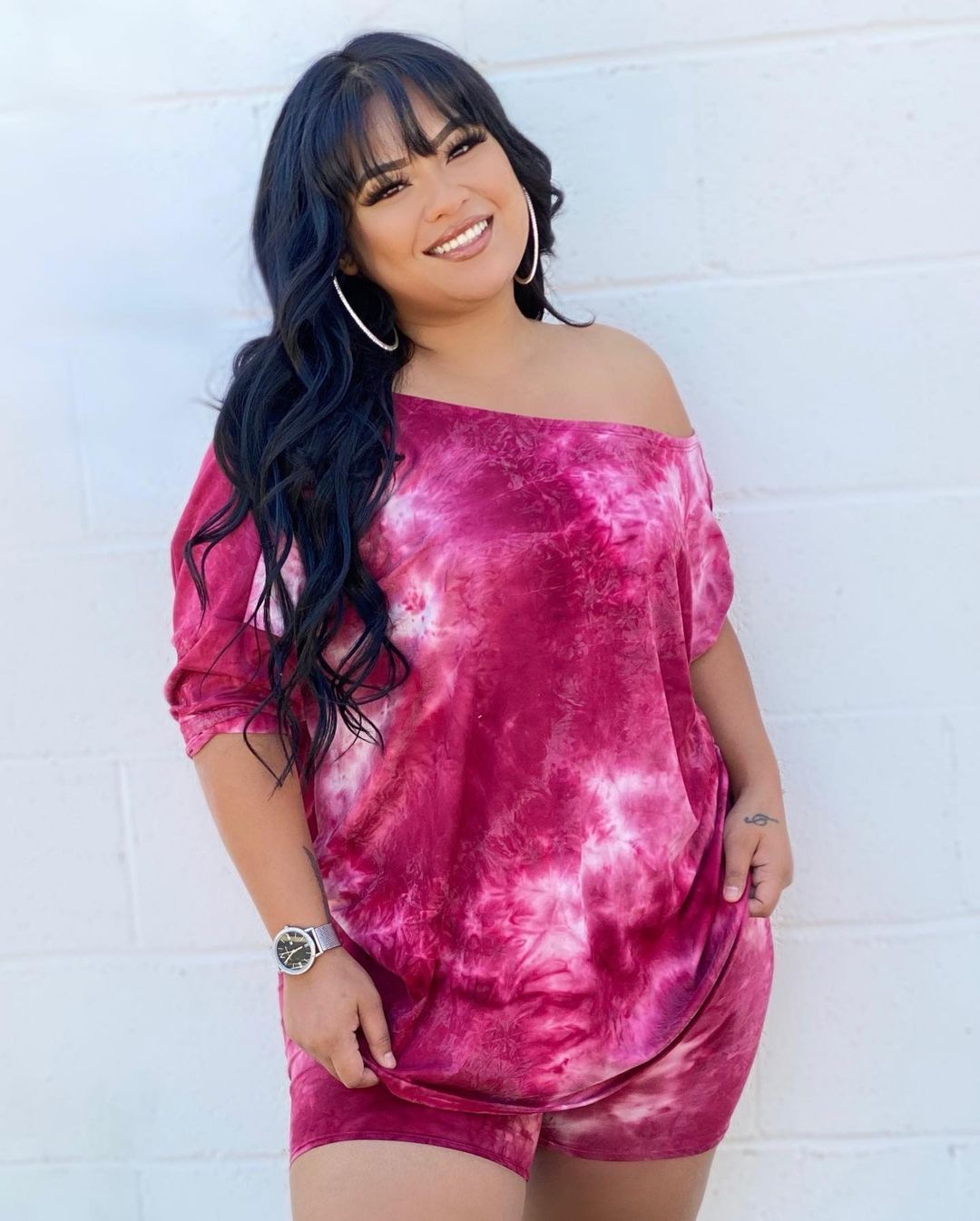 A model wearing a red and pink tie-dye print top and shorts set.