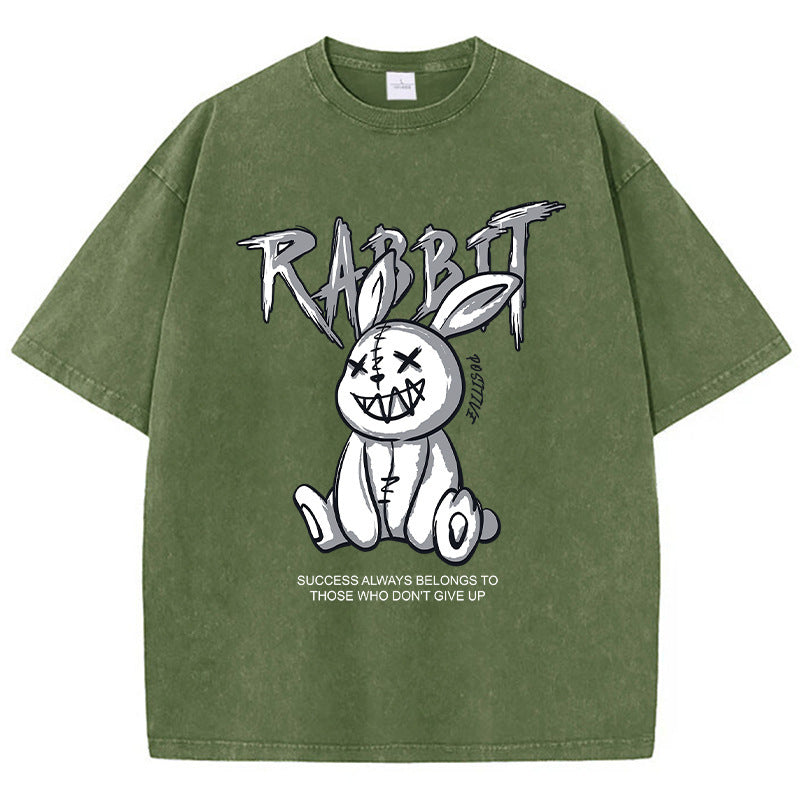 A green T-shirt featuring a graphic print of a stylized rabbit with the text 'RABBIT' above it. The graphic has a black and white color scheme.