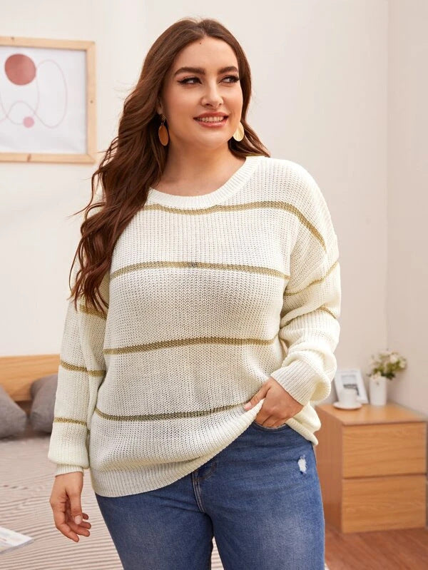 A woman wearing a striped, hand-crocheted white pullover with sequin details paired with jeans.