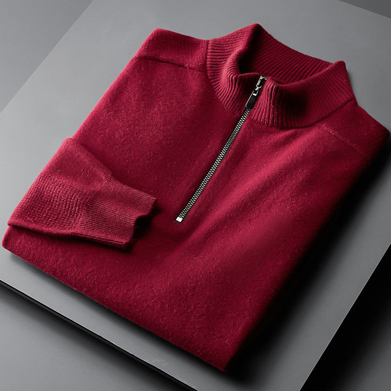 A red oversized cardigan with a zipper at the neck, laid flat on a grey surface.