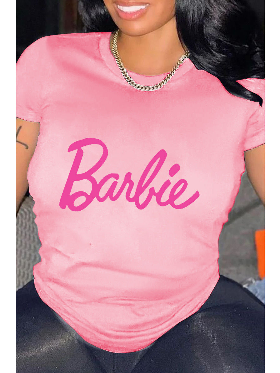 A person wearing a pink relaxed fit t-shirt with the pink 'Barbie' text graphic printed on the front.