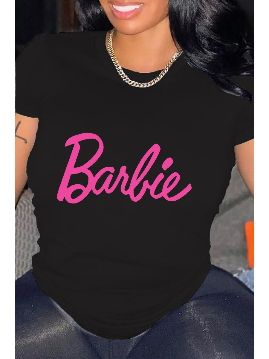 A person wearing a black relaxed fit t-shirt with the pink 'Barbie' text graphic printed on the front.