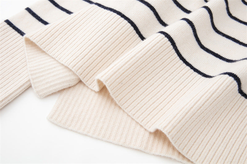 A woman wearing a beige and black striped knit pullover.