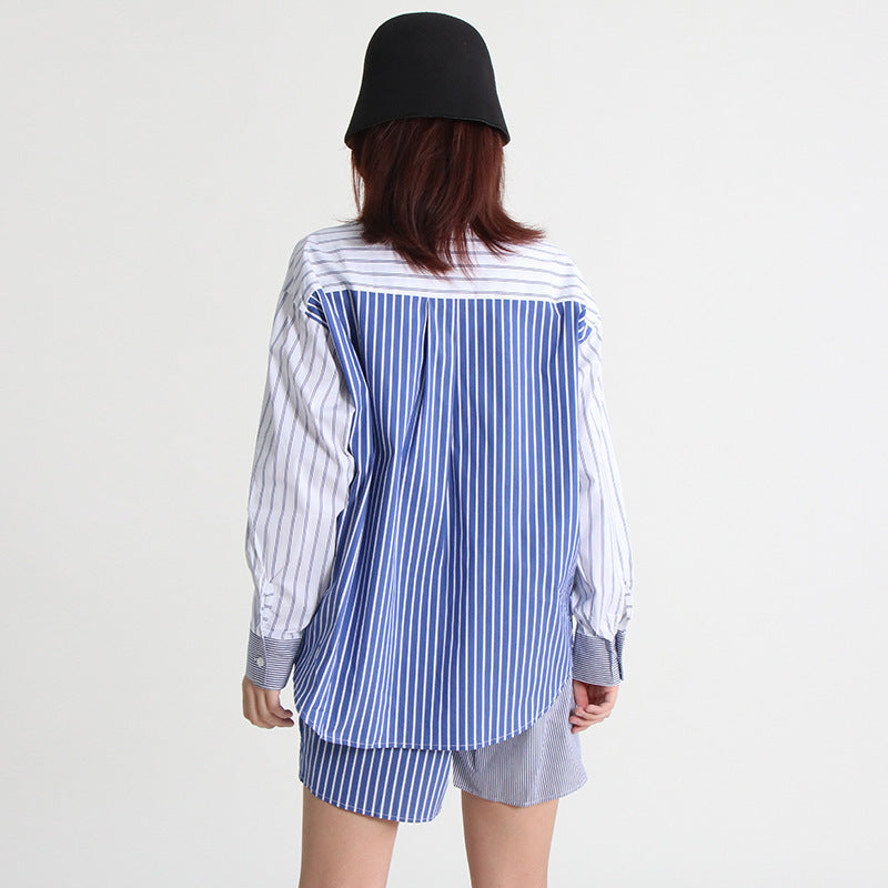 A woman wearing a long-sleeve shirt and shorts set with a striped pattern, paired with a black hat and sunglasses.