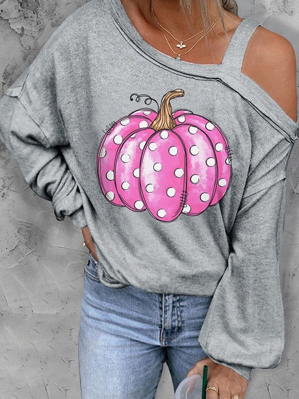 Gray sweatshirt with pink polka dot pumpkins and blue jeans on a gray background