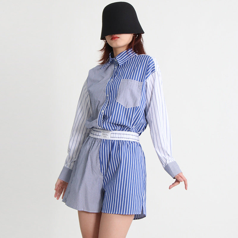 A woman wearing a long-sleeve shirt and shorts set with a striped pattern, paired with a black hat and sunglasses.