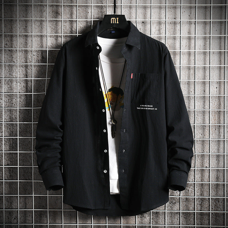 A male fashion model wearing a white Urban Wave men's fashion top with a lapel collar, long sleeves, and a slim fit. The top is displayed in an urban setting with a tiled wall in the background.