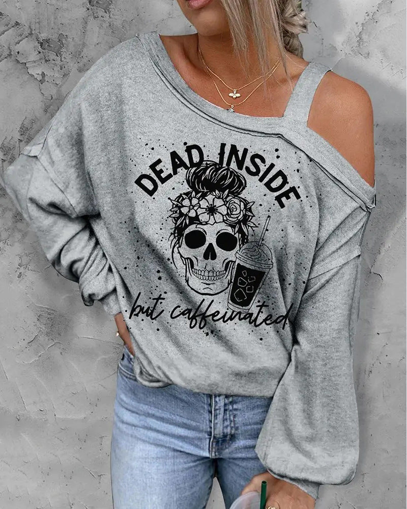 Gray sweatshirt with skull and coffee graphic and text 'Dead Inside but Caffeinated' worn by a person against a gray background.