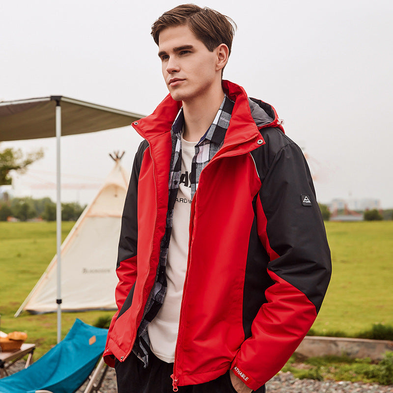 A person wearing a red Storm Core Expedition Jacket with a hood.