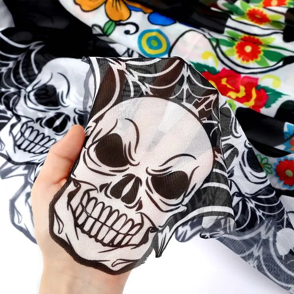 Hand holding a skull design against a colorful floral and skull patterned background