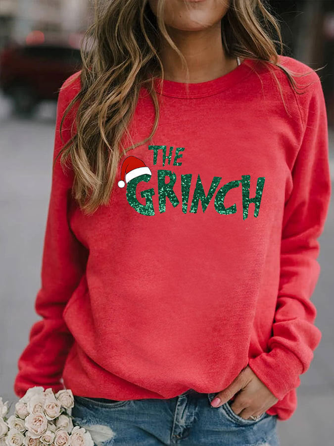 Red sweatshirt with 'The Grinch' text and Santa hat graphic worn by a person.