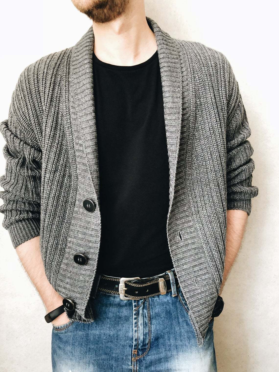 A person wearing a brown Urban Knit V-Neck Cardigan over a black t-shirt and blue jeans.