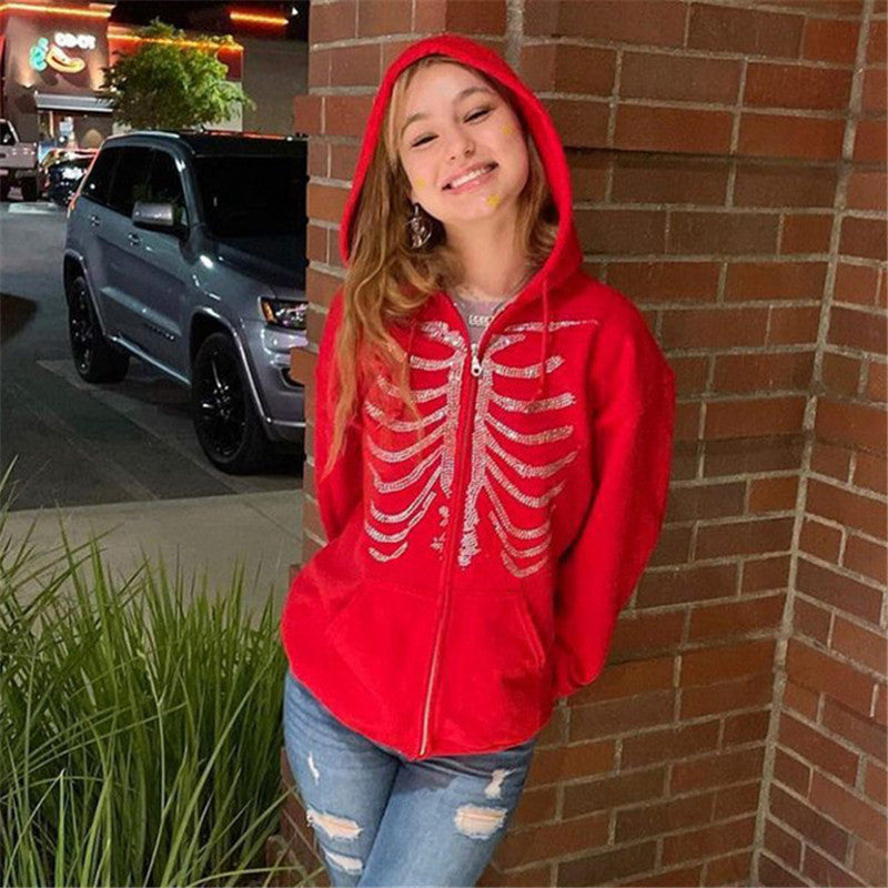 A woman wearing a Urban Sparkle Butterfly Jacket with rhinestone butterfly embroidery, a V-neck collar, and a full zipper closure. She is also wearing a white belt and has a necklace.