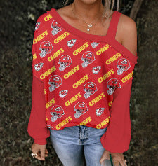 Person wearing a red long-sleeve top with a pattern, standing outdoors.