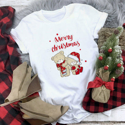 White t-shirt with Christmas-themed design featuring two bears, a tree, and stockings on a plaid fabric background.