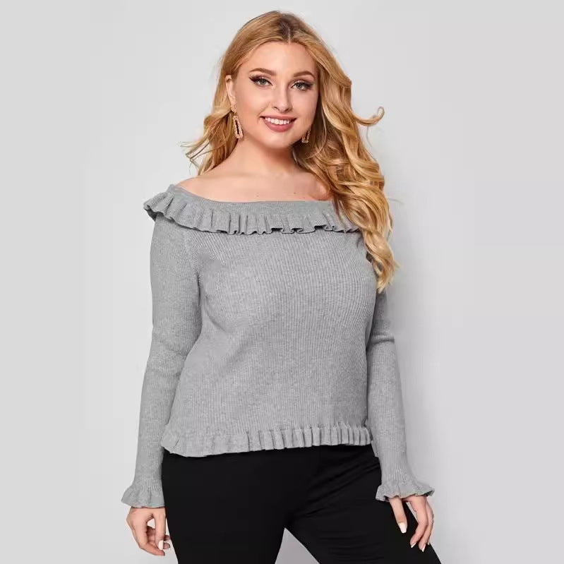 A woman wearing a gray off-shoulder sweater with ruffle detailing and long sleeves.
