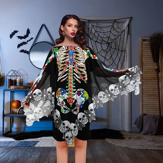 Woman wearing a colorful skeleton-themed cape in a Halloween decorated room.