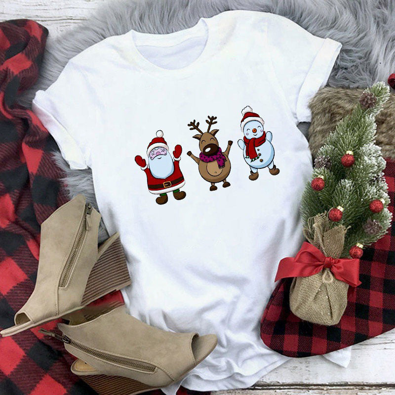 White t-shirt with Christmas-themed design featuring Santa, reindeer, and snowman on a plaid fabric background.