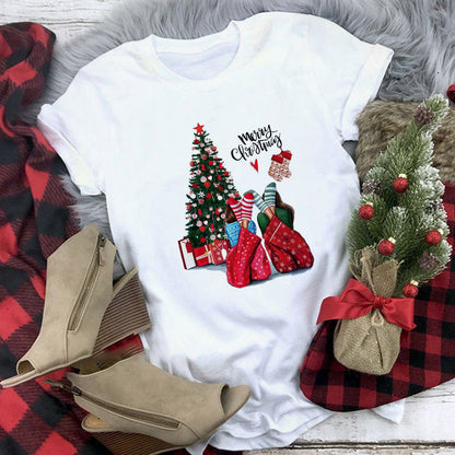 White t-shirt with Christmas-themed design featuring trees, stockings, and boots on a plaid fabric background.